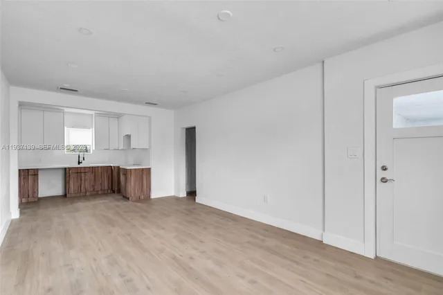 a view of kitchen with wooden cabinet and a refrigerator