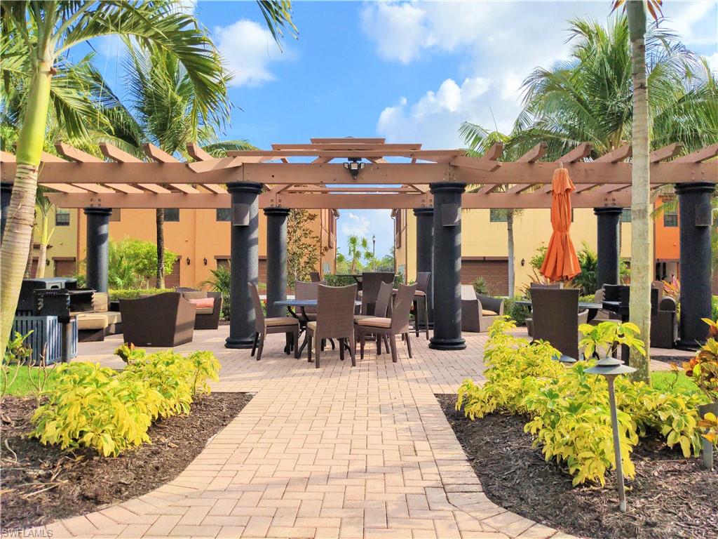9063 Capistrano Street North, Unit 4405 Naples, FL 34113 - Photo 22 of 37 a view of a patio with couches table and chairs and potted plants