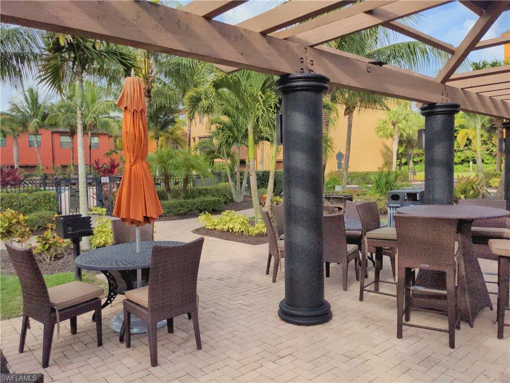 9063 Capistrano Street North, Unit 4405 Naples, FL 34113 - Photo 23 of 37 a view of a patio with a table chairs and a porch