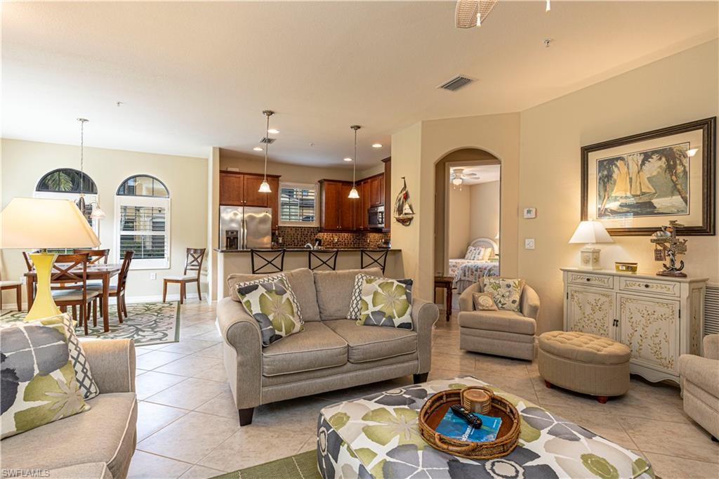 9063 Capistrano Street North, Unit 4405 Naples, FL 34113 - Photo 4 of 37 a living room with furniture and wooden floor