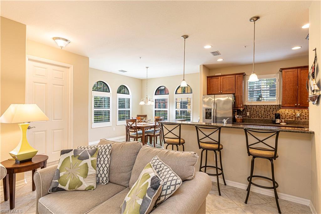 9063 Capistrano Street North, Unit 4405 Naples, FL 34113 - Photo 6 of 37 a living room with furniture kitchen view and a large window