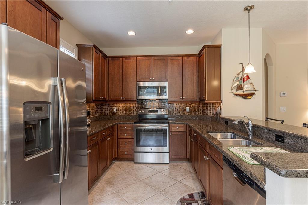 9063 Capistrano Street North, Unit 4405 Naples, FL 34113 - Photo 8 of 37 a kitchen with stainless steel appliances granite countertop a sink stove and refrigerator