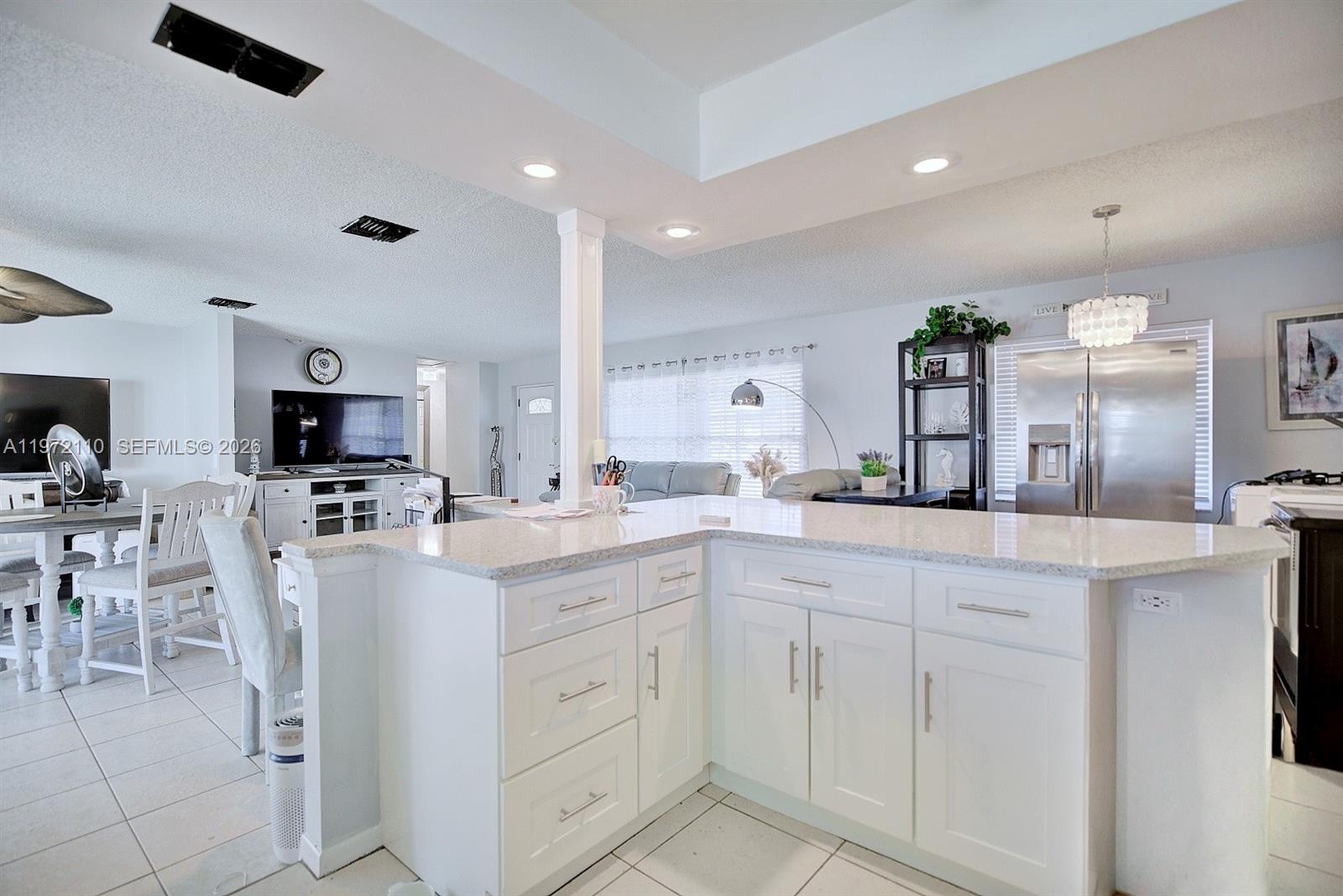 4131 Bianca Street Sebring, FL 33872 - Photo 11 of 30 a large white kitchen with cabinets and chairs