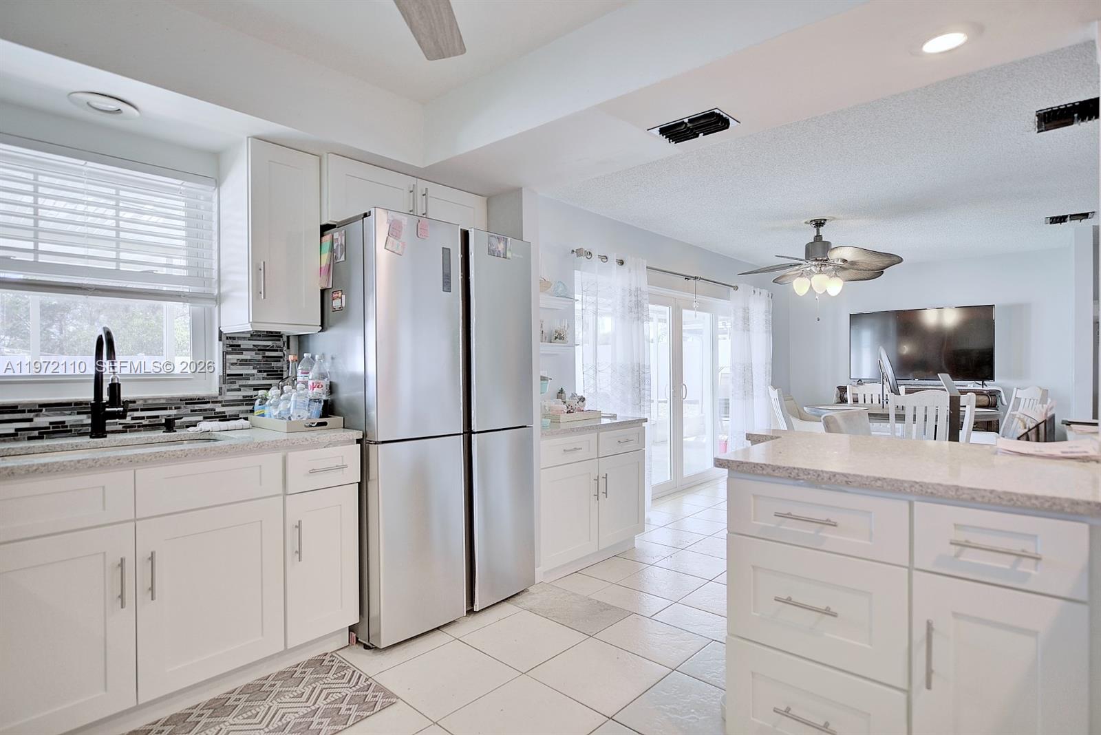 4131 Bianca Street Sebring, FL 33872 - Photo 12 of 30 a kitchen with a sink refrigerator and cabinets