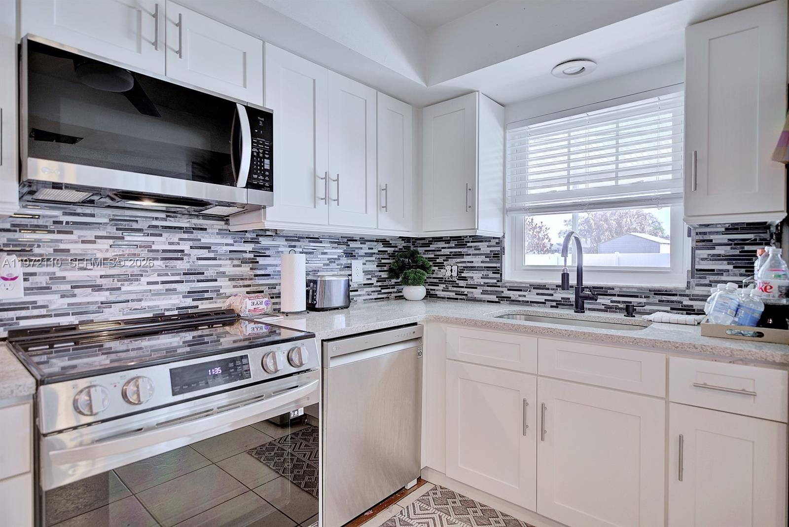 4131 Bianca Street Sebring, FL 33872 - Photo 13 of 30 a kitchen with white cabinets appliances and a window