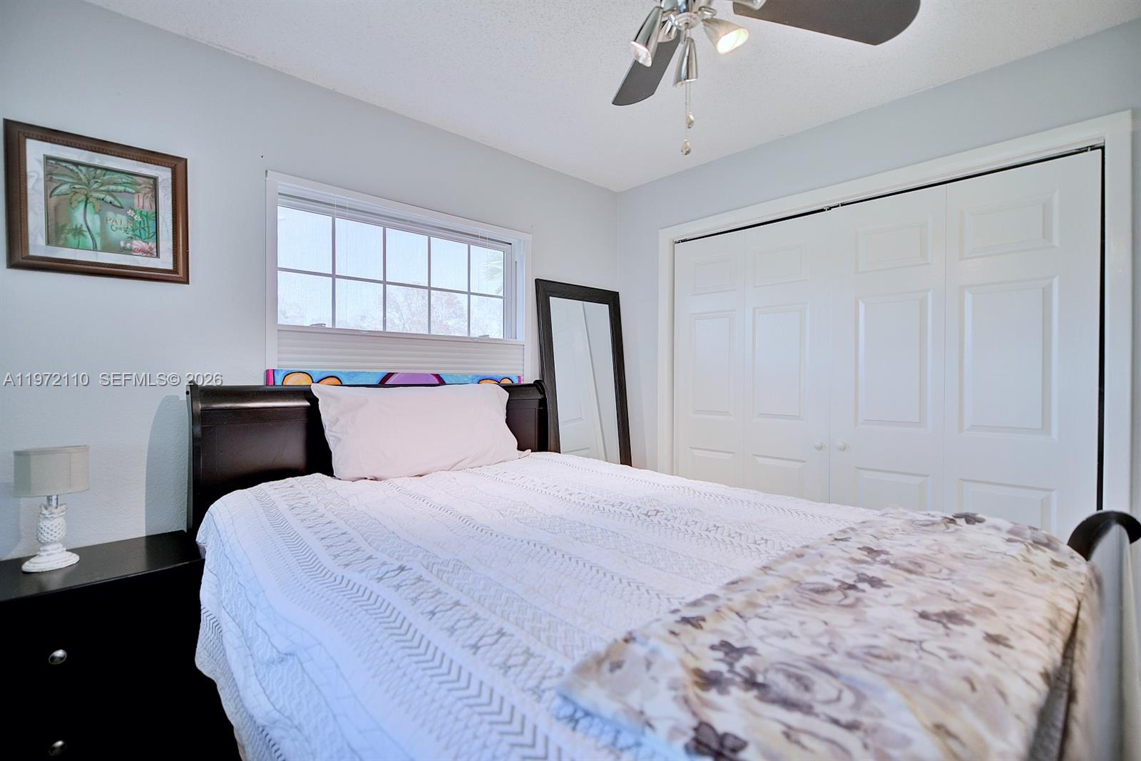 4131 Bianca Street Sebring, FL 33872 - Photo 19 of 30 a bedroom with a large bed and a chandelier