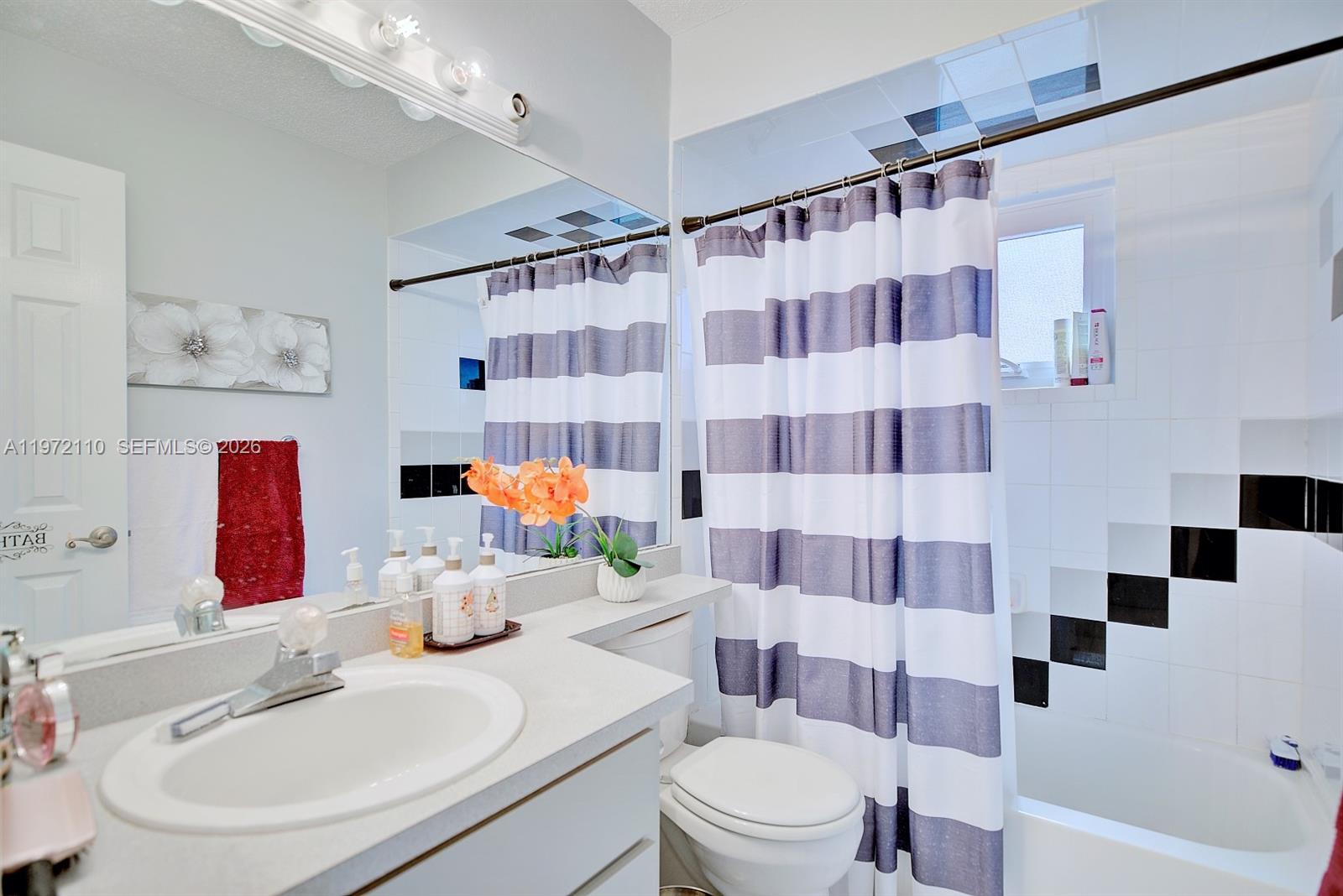 4131 Bianca Street Sebring, FL 33872 - Photo 20 of 30 a bathroom with a sink a toilet and shower curtain