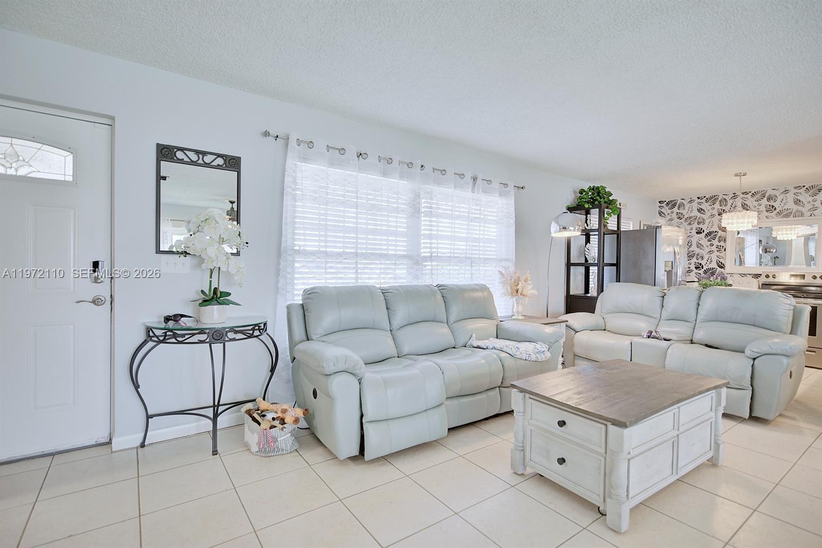 4131 Bianca Street Sebring, FL 33872 - Photo 4 of 30 a living room with furniture and a chandelier