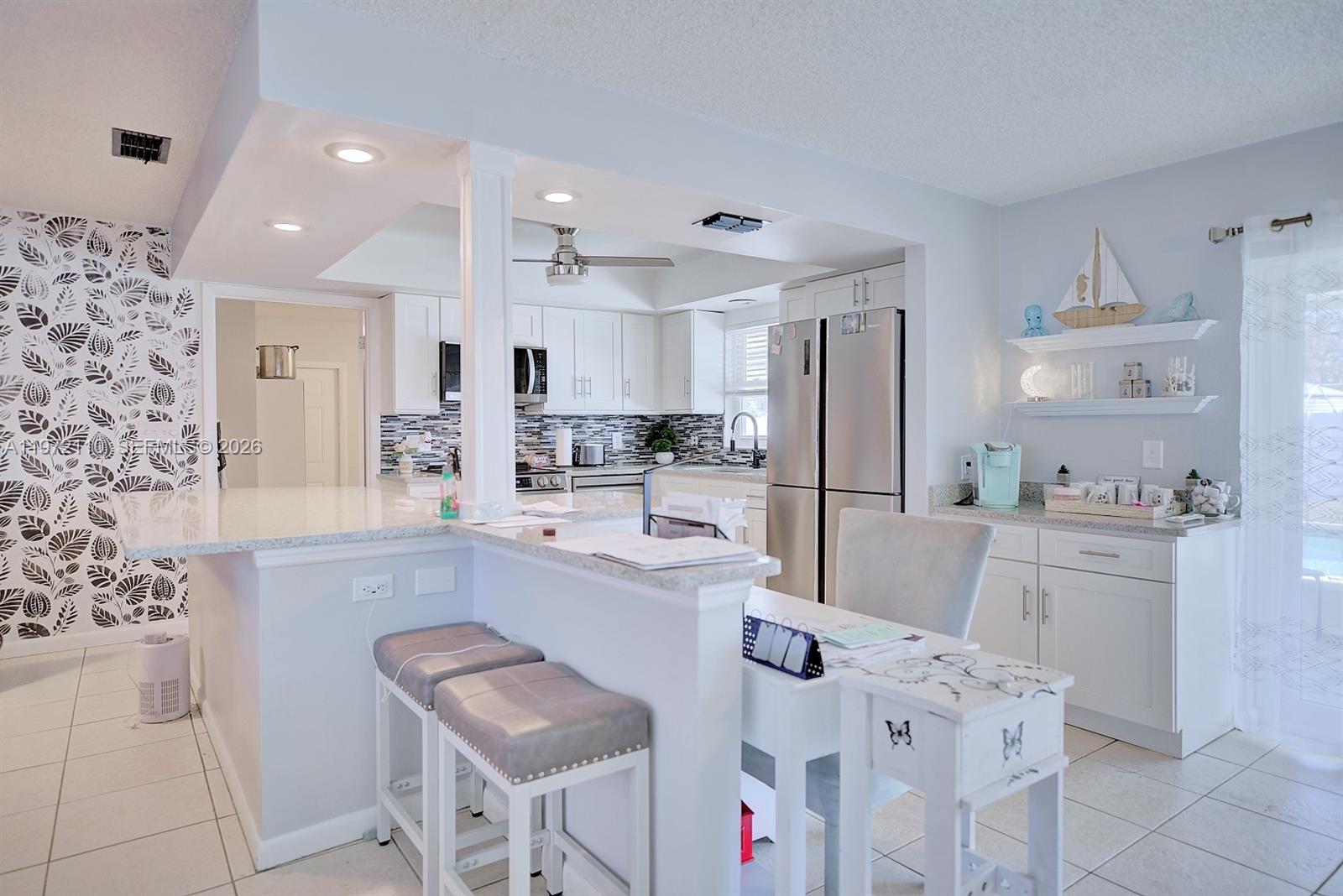 4131 Bianca Street Sebring, FL 33872 - Photo 8 of 30 a kitchen with white cabinets and stainless steel appliances