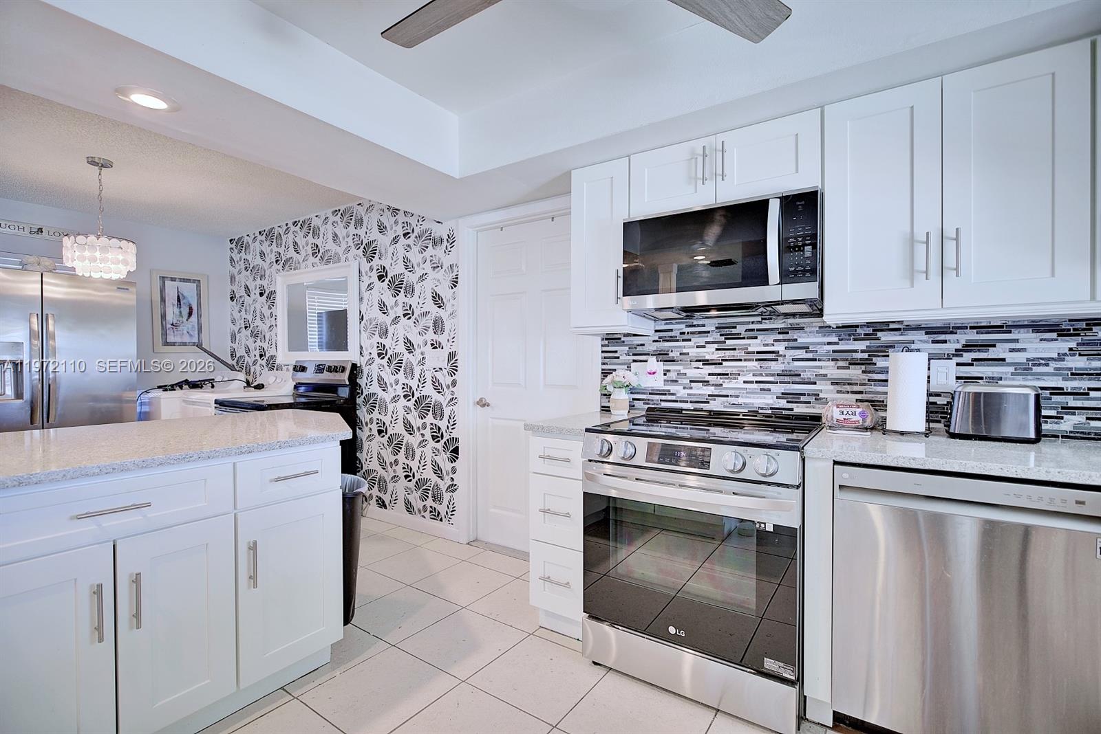 4131 Bianca Street Sebring, FL 33872 - Photo 10 of 30 a kitchen with white cabinets stainless steel appliances and sink