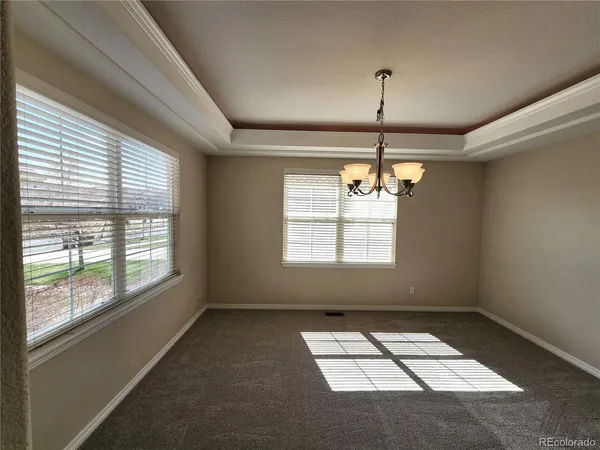 a view of wooden floor chandelier and window in a room