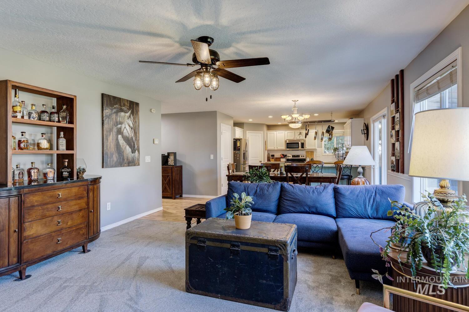 4428 West Campfire Street Meridian, ID 83646 - Photo 11 of 46 Carpeted living area featuring ceiling fan and a chandelier