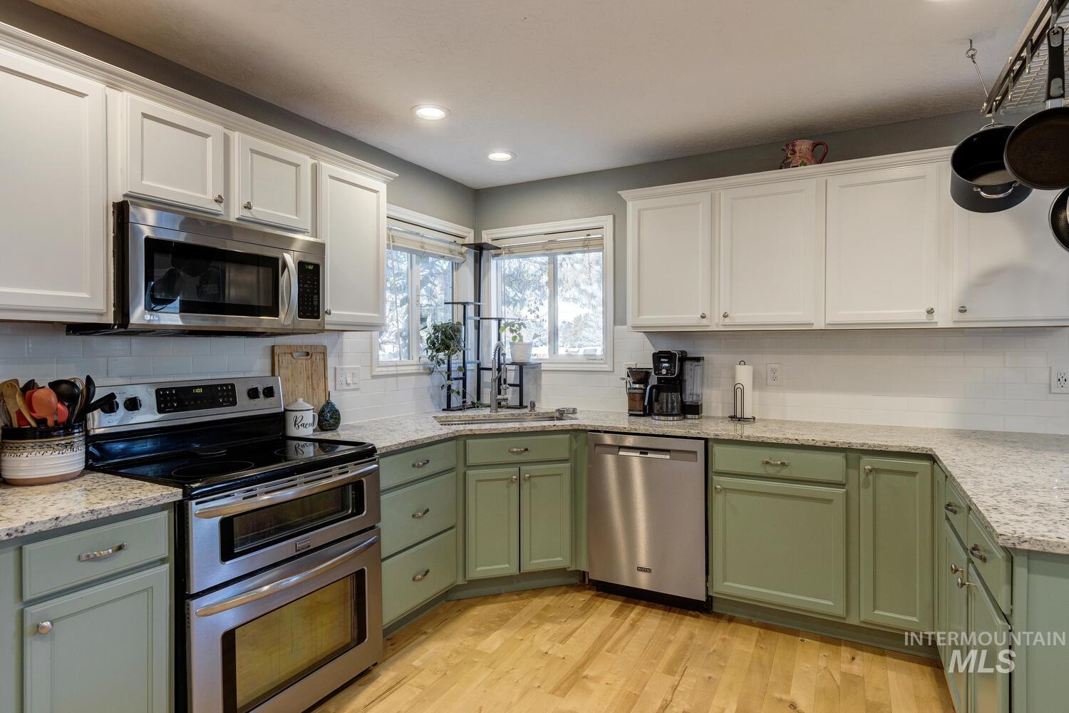 4428 West Campfire Street Meridian, ID 83646 - Photo 16 of 46 Kitchen with green cabinetry, stainless steel appliances, white cabinets, and recessed lighting