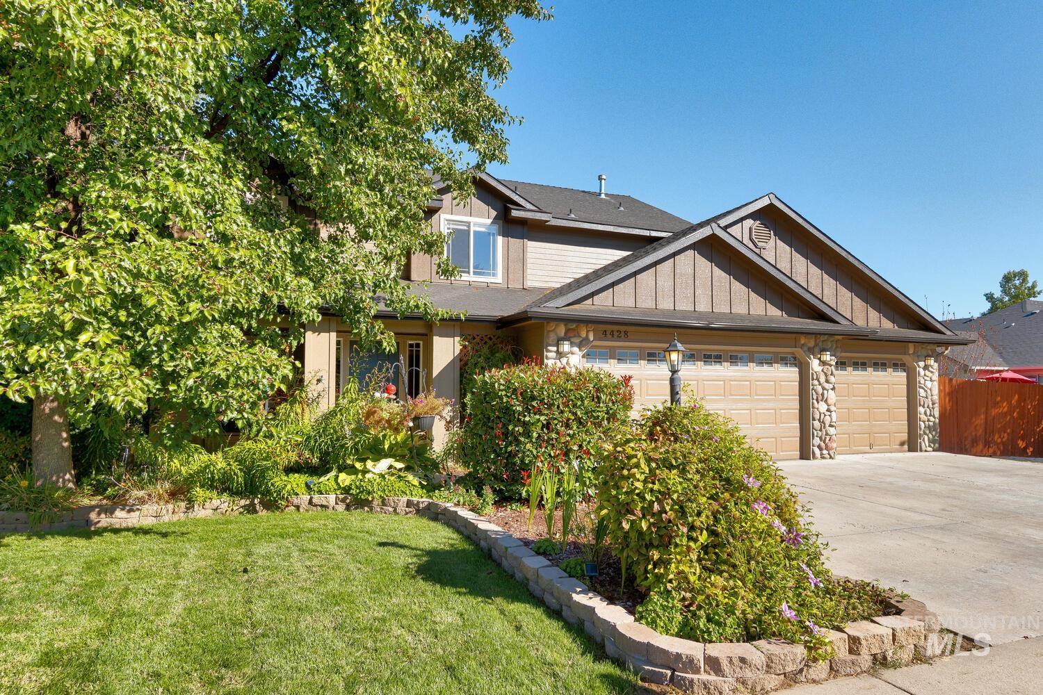 4428 West Campfire Street Meridian, ID 83646 - Photo 2 of 46 Craftsman-style house featuring driveway, stone siding, a front lawn, and a garage