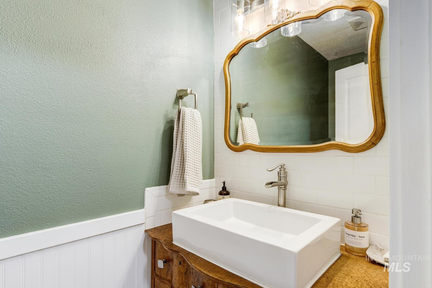 4428 West Campfire Street Meridian, ID 83646 - Photo 21 of 46 Bathroom featuring a textured wall, vanity, and wainscoting