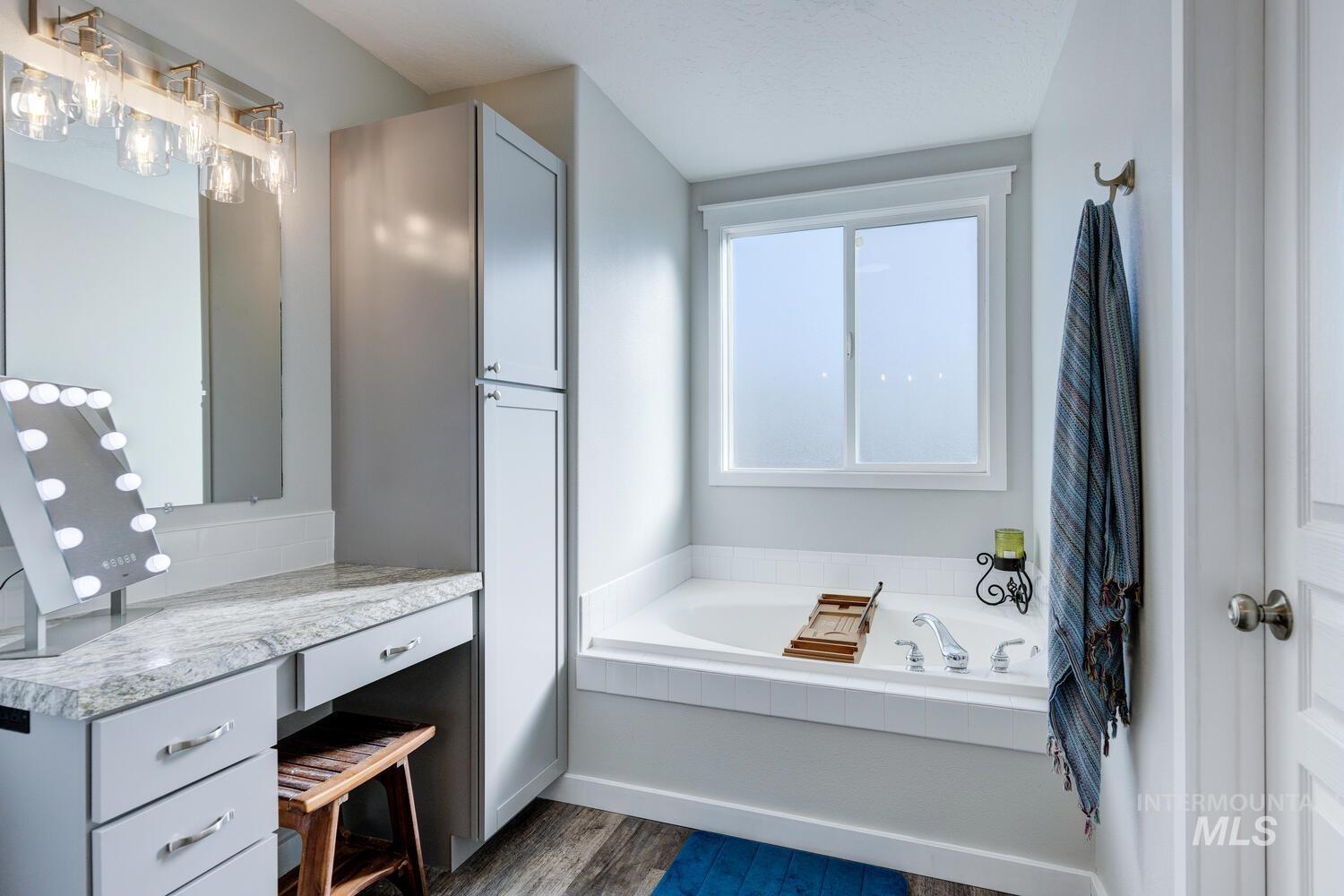 4428 West Campfire Street Meridian, ID 83646 - Photo 31 of 46 Bathroom with a garden tub, vanity, and dark wood-type flooring