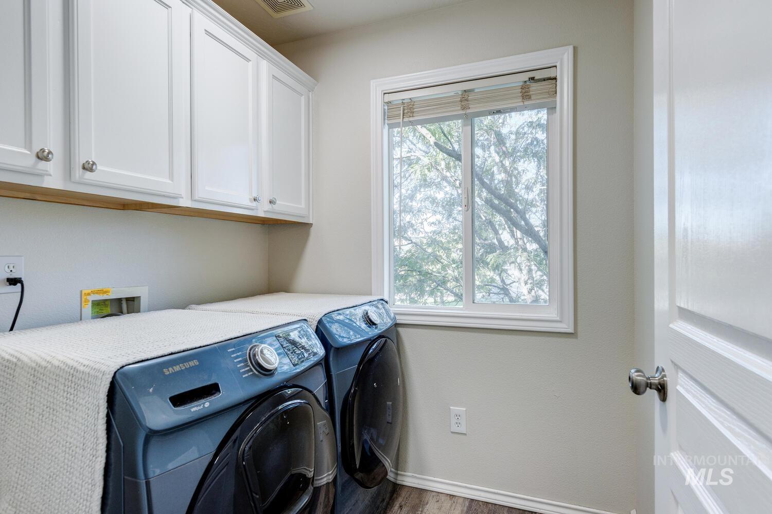 4428 West Campfire Street Meridian, ID 83646 - Photo 40 of 46 Washroom with wood finished floors, cabinet space, and washing machine and dryer