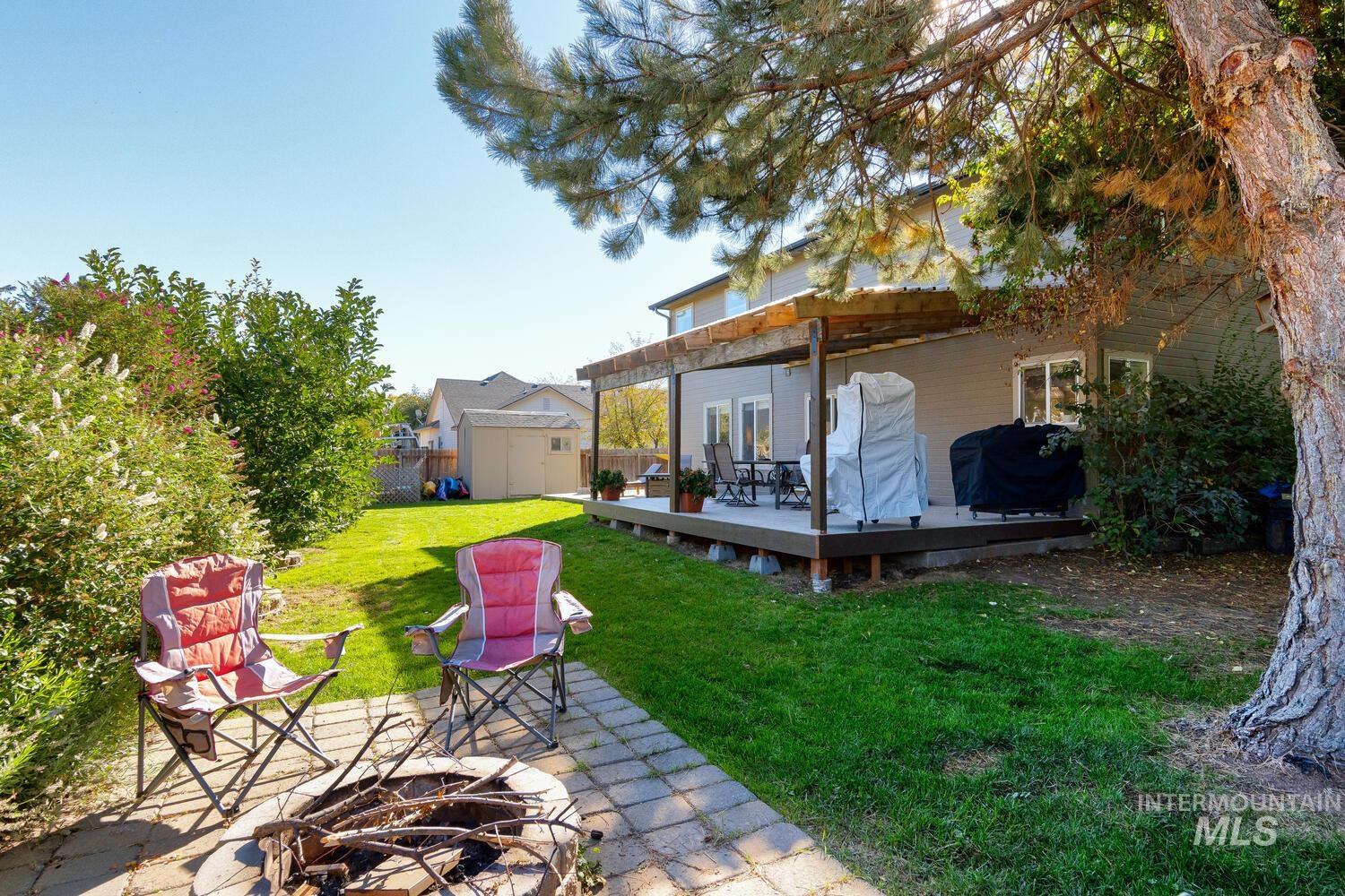 4428 West Campfire Street Meridian, ID 83646 - Photo 42 of 46 Fenced backyard featuring an outdoor fire pit, a storage unit, a wooden deck, and a patio