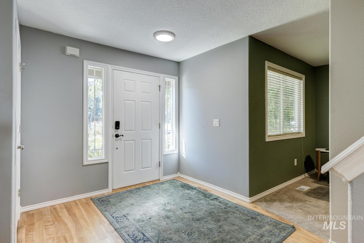 4428 West Campfire Street Meridian, ID 83646 - Photo 6 of 46 Foyer entrance with healthy amount of natural light, light wood-style flooring, and a textured ceiling