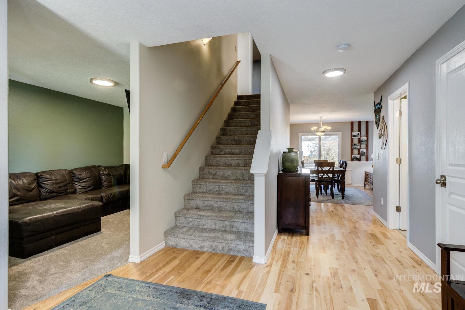 4428 West Campfire Street Meridian, ID 83646 - Photo 7 of 46 Stairs featuring wood finished floors and a chandelier