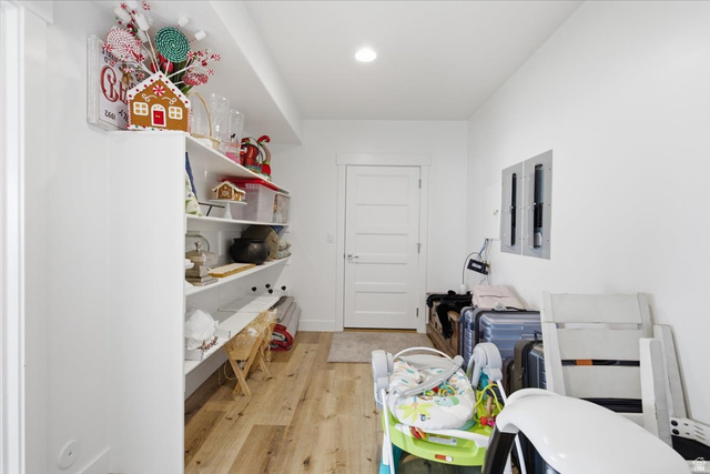 21 Pier Place Tooele, UT 84074 - Photo 63 of 112 Spacious storage area featuring extensive built-in shelving, wood-finish flooring, a white paneled door, and recessed lighting