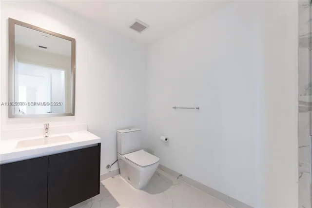 a bathroom with a sink mirror and toilet