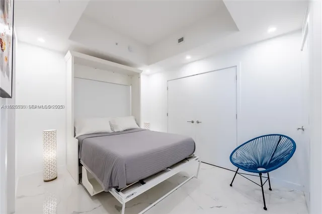 a bedroom with a bed and a chair