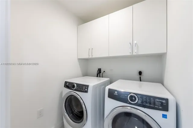 a view of washer and dryer with kitchen in the background