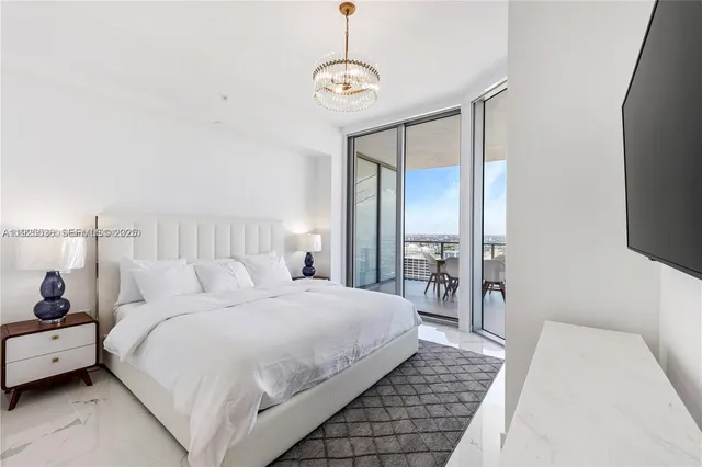 a bedroom with a bed and a chandelier