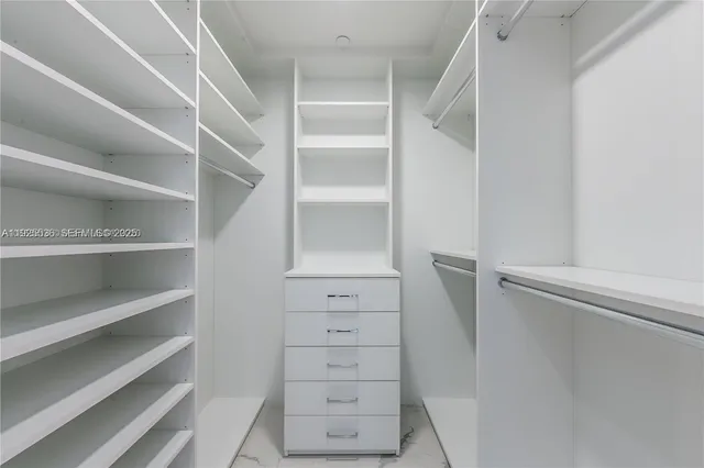 a view of walk in closet with empty racks
