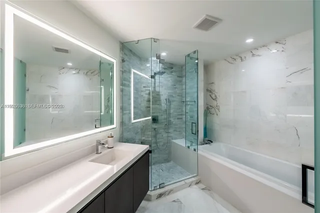 a bathroom with a bathtub shower sink vanity and toilet