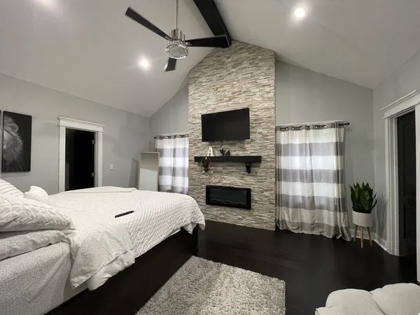 a spacious bedroom with a bed and a fireplace