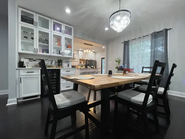 a dining room with a table chairs and kitchen view