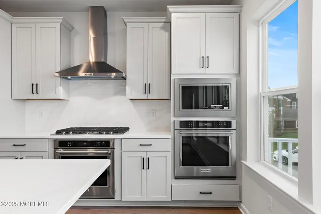 a kitchen with stainless steel appliances granite countertop a stove and a microwave