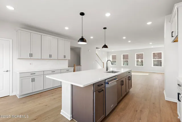 a kitchen with stainless steel appliances granite countertop a sink a stove and a wooden floors
