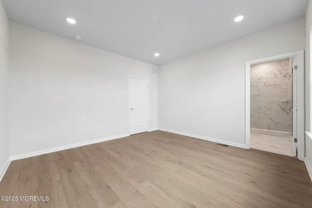 an empty room with wooden floor and door