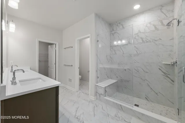 a bathroom with a sink a toilet and shower