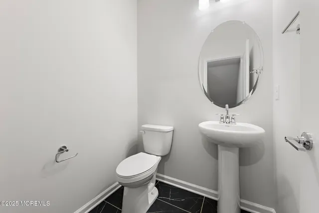 a bathroom with a toilet a sink and mirror