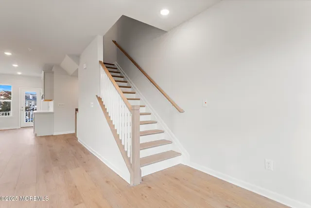 a view of a hallway with wooden floor and staircase