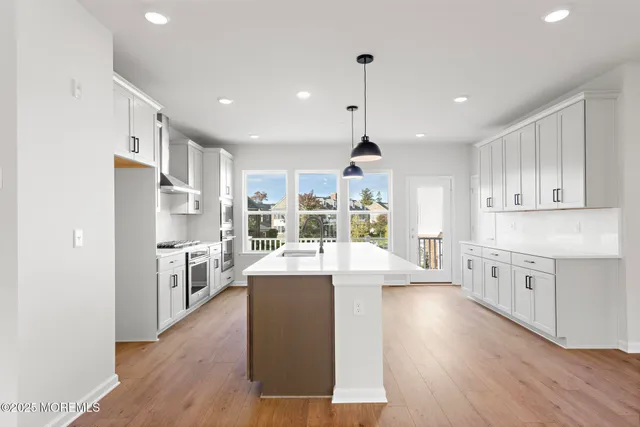 a large kitchen with kitchen island a stove a sink a center island and stainless steel appliances