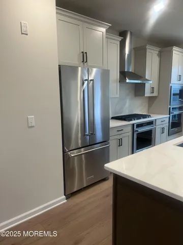 a kitchen with stainless steel appliances a refrigerator and a stove top oven