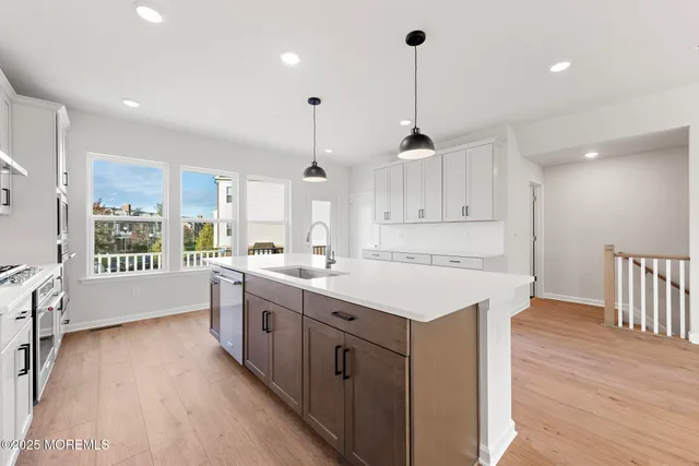 a large kitchen with kitchen island a sink a center island and wooden floor