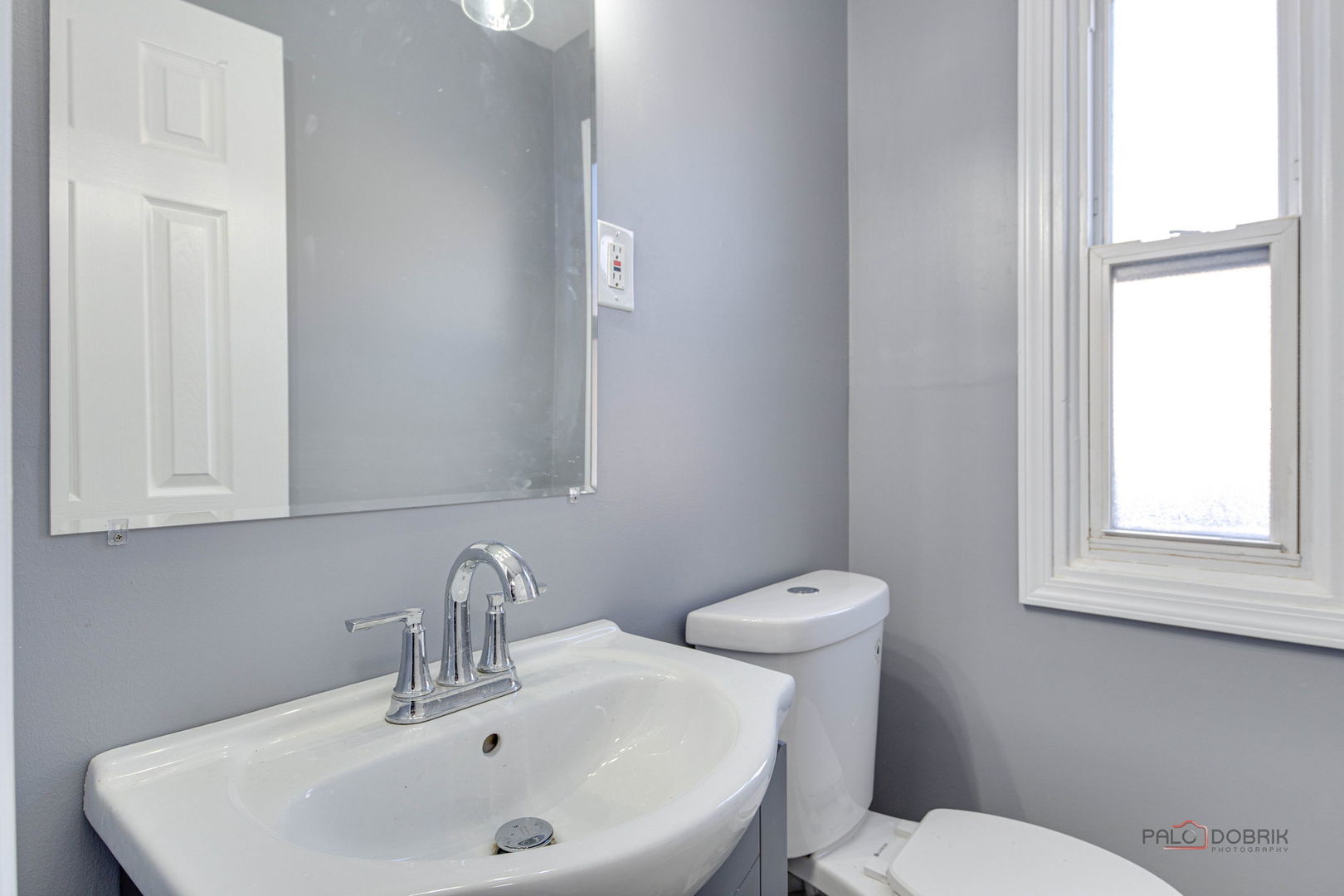 9463 Niles Center Road, Unit E Skokie, IL 60076 - Photo 16 of 30 a bathroom with a sink a toilet and a mirror
