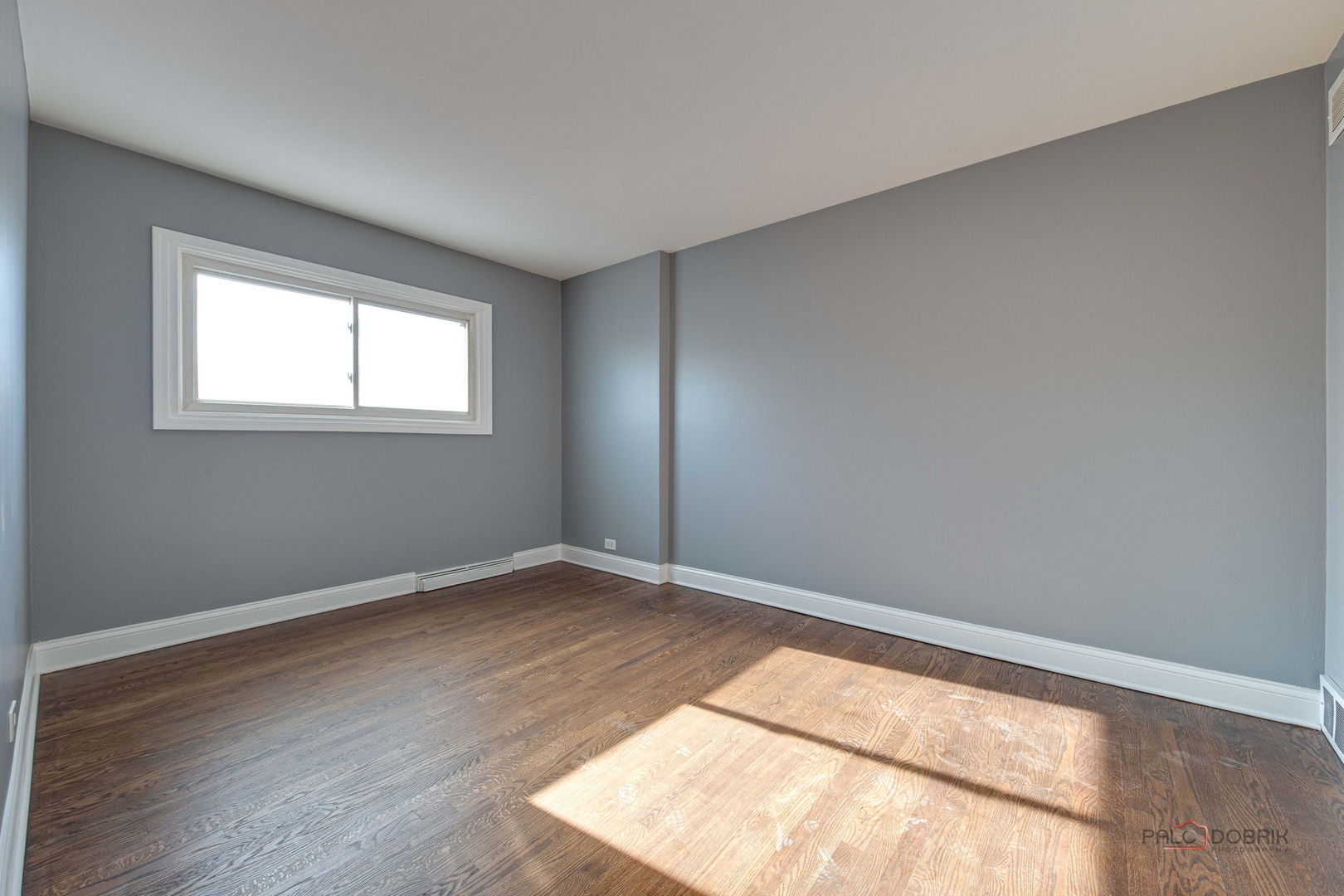 9463 Niles Center Road, Unit E Skokie, IL 60076 - Photo 21 of 30 an empty room with wooden floor and windows