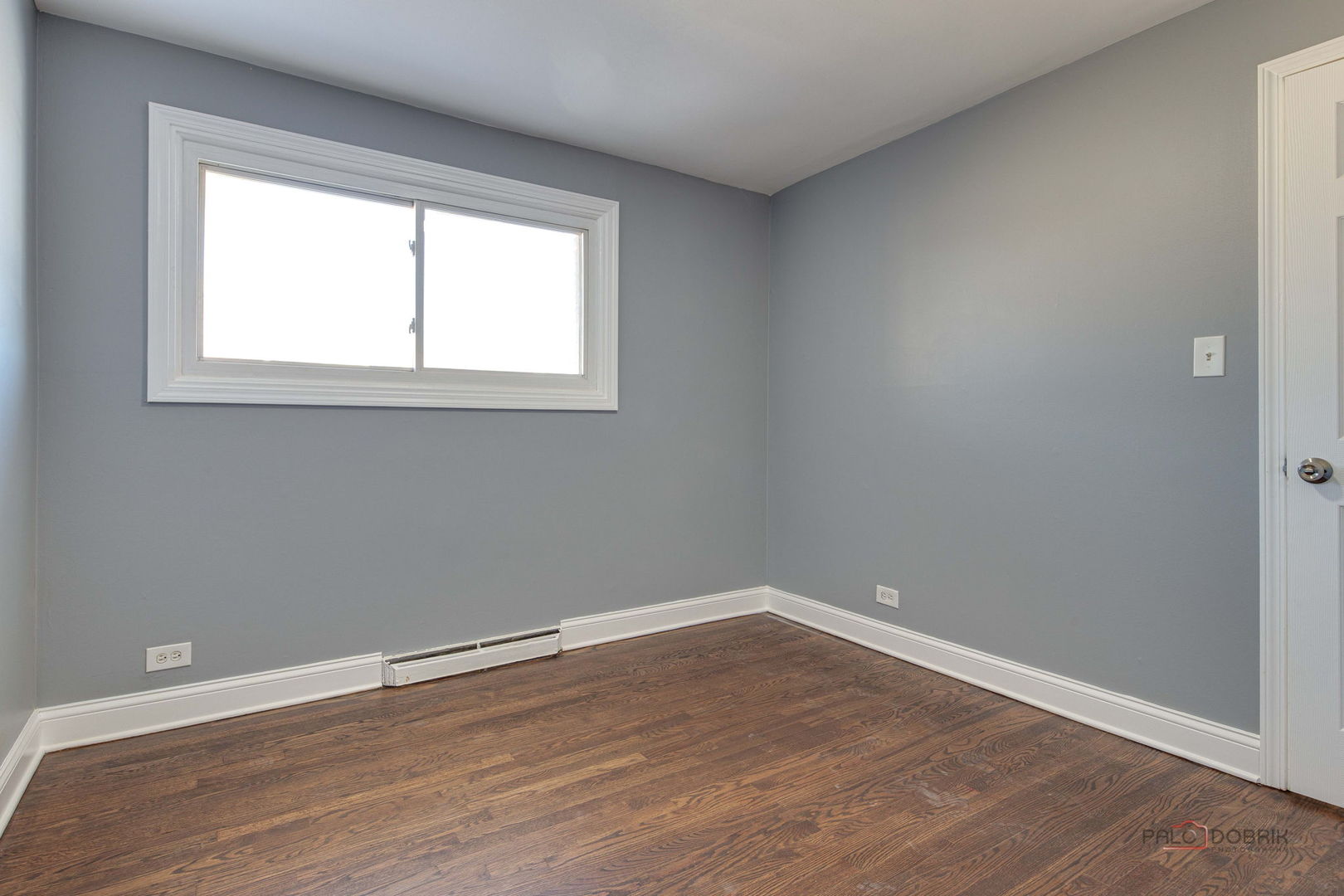 9463 Niles Center Road, Unit E Skokie, IL 60076 - Photo 22 of 30 an empty room with wooden floor and windows