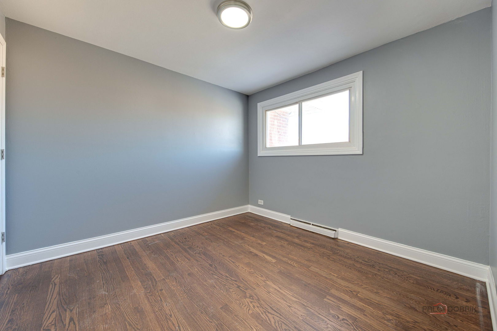 9463 Niles Center Road, Unit E Skokie, IL 60076 - Photo 23 of 30 an empty room with wooden floor and windows