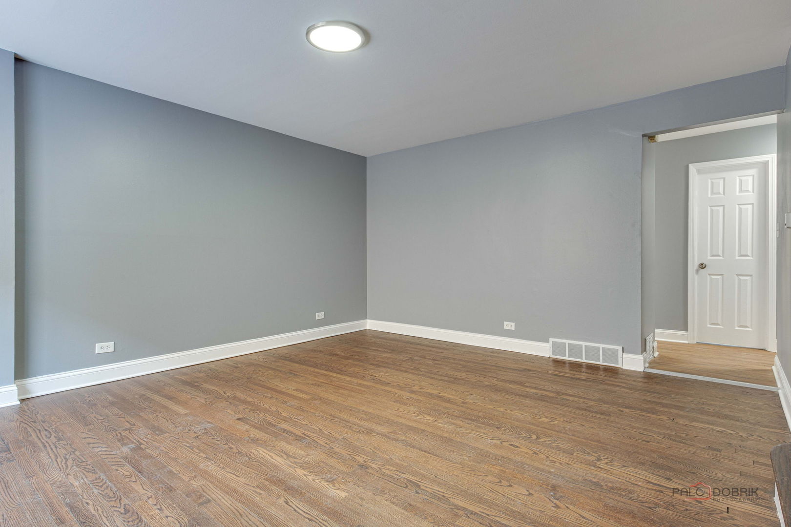 9463 Niles Center Road, Unit E Skokie, IL 60076 - Photo 5 of 30 a view of an empty room with wooden floor and a window