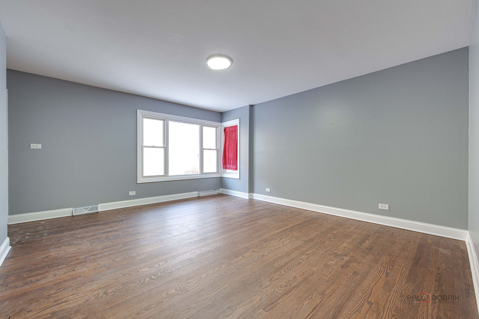 9463 Niles Center Road, Unit E Skokie, IL 60076 - Photo 8 of 30 a view of an empty room with wooden floor and a window