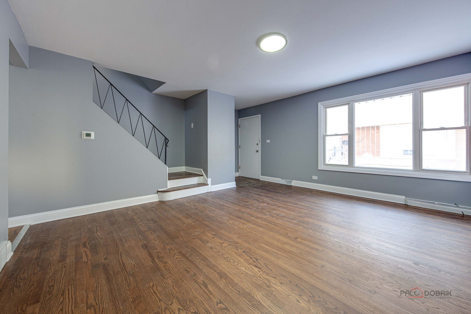 9463 Niles Center Road, Unit E Skokie, IL 60076 - Photo 9 of 30 a view of an empty room with wooden floor and a window