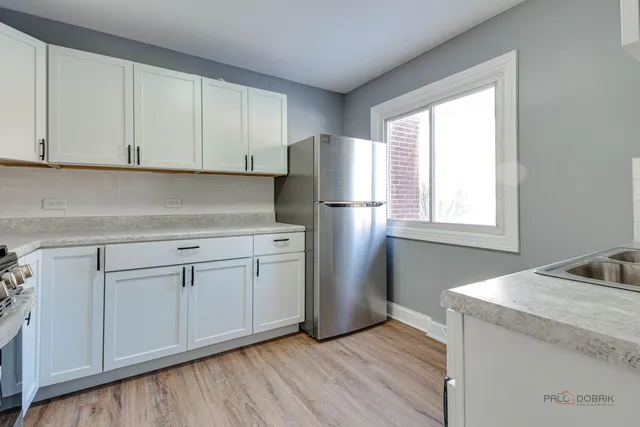 a kitchen with a refrigerator sink and cabinets